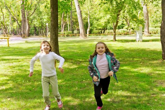 Photo of two running girls in summer