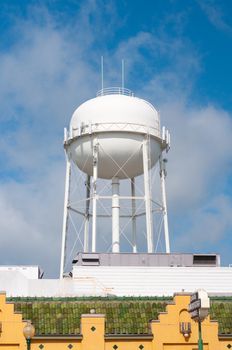 City water tower in downtown area with blue sky in background.