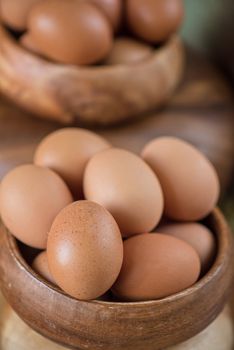 Fresh eggs at wooden plate closeup