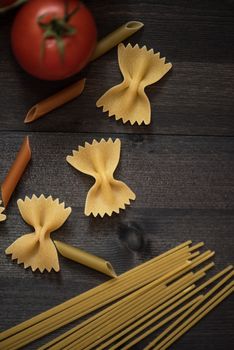 food background on rustic wood with pasta and tomatoes