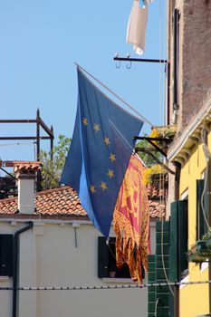Old building with the flags of Venice, Italy, and the European Union. Venetian architecture, Venice, Italy