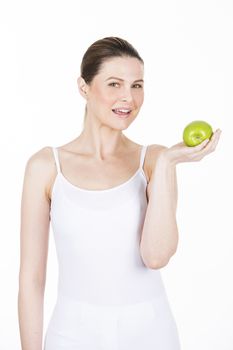 young woman holding an apple and looking at camera
