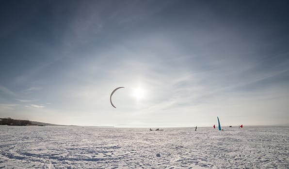 Kite surfer being pulled by his kite across the snow