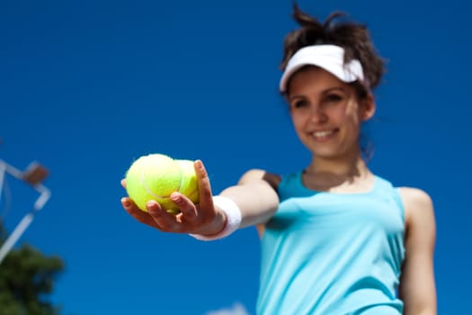 Young woman playing tennis, summertime saturated theme