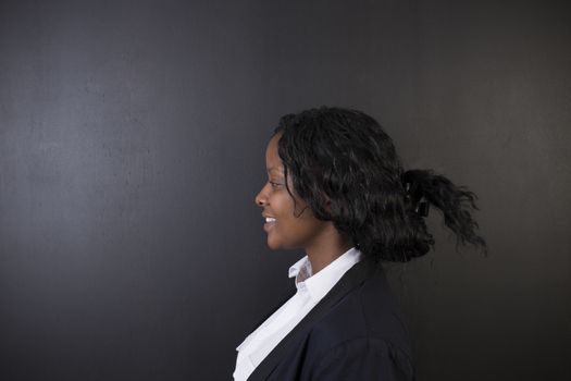 South African or African American woman teacher on chalk black board background