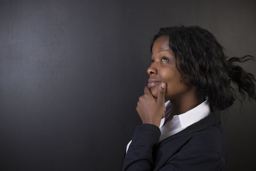 South African or African American woman teacher or student think or thinking on chalk black board background