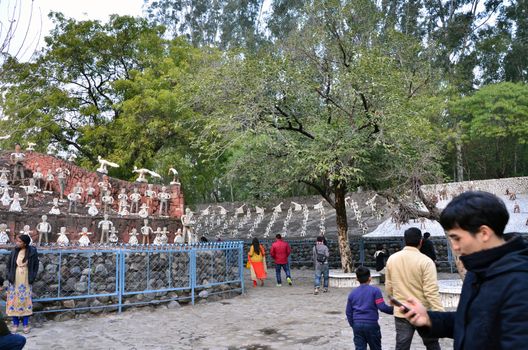 Chandigarh, India - January 4, 2015: Tourist visit Rock statues at the rock garden on January 4, 2015 in Chandigarh, India. The rock garden was founded by artist Nek Chand in 1957 and is made completely of recycled waste.