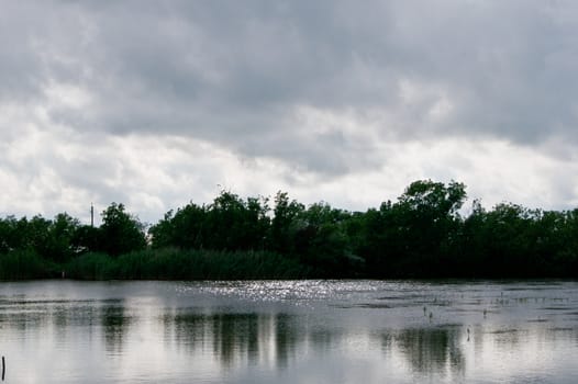 Dark clouds and water glitter on the lake .