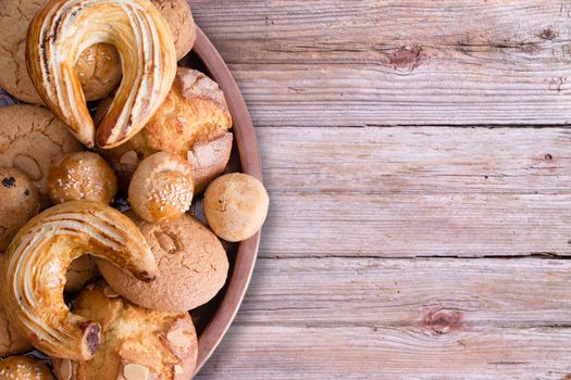 Close up Tasty Fresh Homemade Turkish Pastries on Tray with Croissant, Ay Coregi, Almond Macaroon and Other Mini Cookies, on Top of Wooden Table with Copy Space.