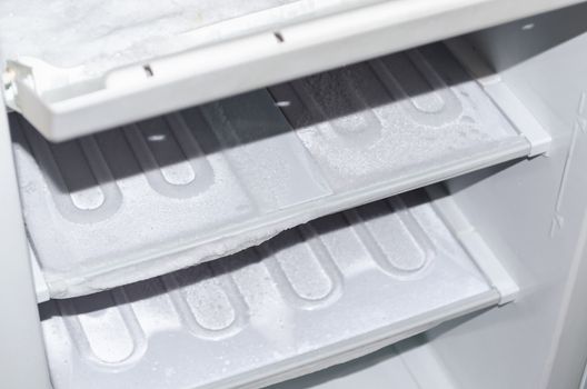 View of an empty freezer that will defrost.