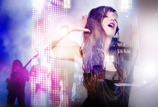 Live music concept. Beautiful woman listening to music and singing with live music background. LED stage lights