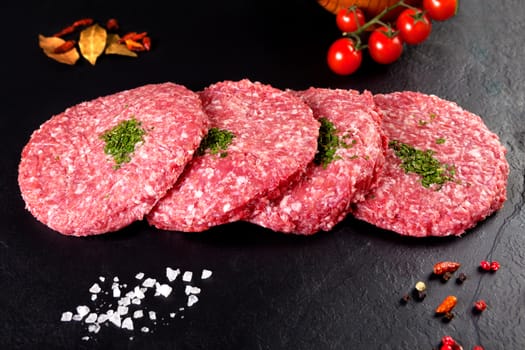 Meat. Raw meat. burger steak on black background with herbs and tomato. Food