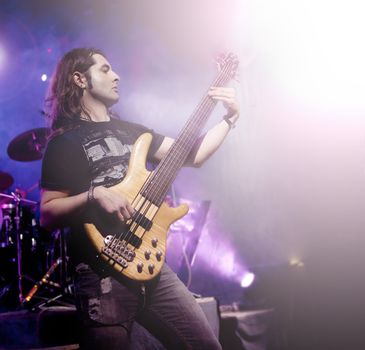 Man playing bass guitar in live concert sequence. Live music background