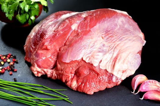 Fresh and raw meat. Whole piece of red meat ready to cook on the grill or BBQ .Background black blackboard. Food