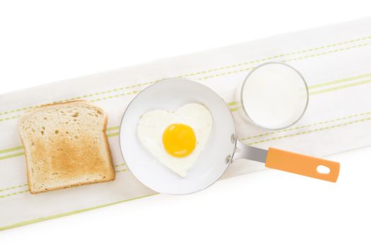 Fried egg in heart shape on pan with toast and milk, top view. I love breakfast. Fresh modern image language. Culinary arts. 