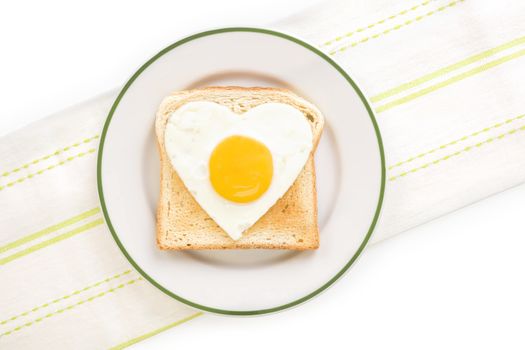 Fried egg sunnyside in heart shape on plate, top view. I love breakfast. Fresh modern image language. Culinary arts. 