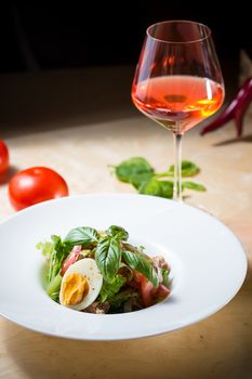 Closeup of plate of spring mix salad with strawberry, eggs and tuna