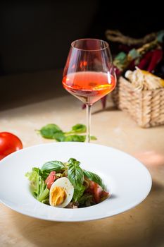 Closeup of plate of spring mix salad with strawberry, eggs and tuna