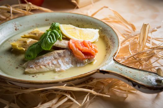 Fish fillet with artichokes and tomatoes with lemon