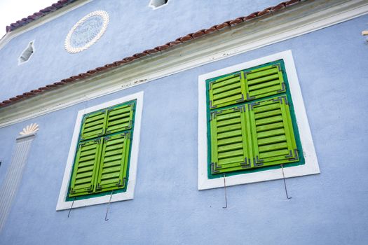 Viscri, Romania - June 23, 2013: Blue painted traditional house with green shutters from Viscri village in Transylvania, Romania