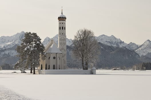 A church in a winter landscape with some mountains in the background