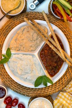 A selection of party dips with bread sticks and other crudites.