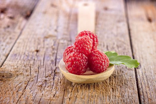 fresh berries in wooden spoon on wooden table