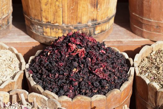 dried hibiscus petals in wooden container on street stall in tropical country