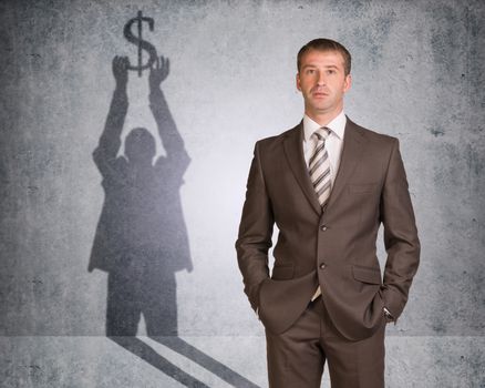 Businessman with shadow holding dollar sign on wall texture background, looking at camera