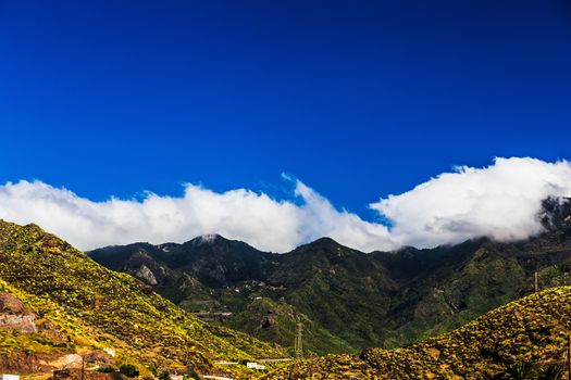 Mountain and clouds on blue sky background