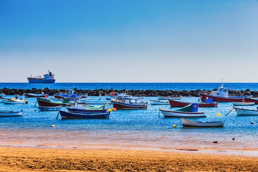 Boats on the water in harbor or port with ship at background
