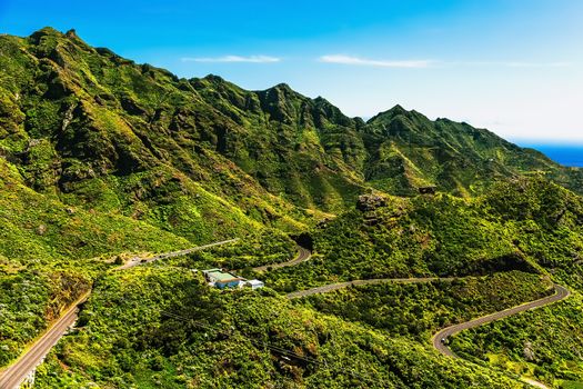 Green mountains or rocks valley with winding or serpantine road and sky nature landscape in Tenerife Canary island, Spain at summer