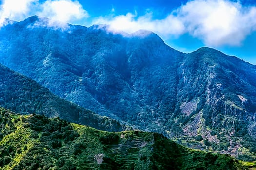 Mountains or rock with clouds over peak