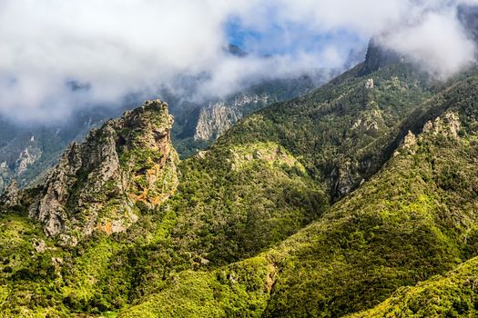 Green mountain and rocks with clouds
