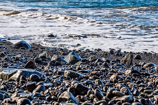 Stones and water of ocean with waves on the beach coast or shore of ocean or sea