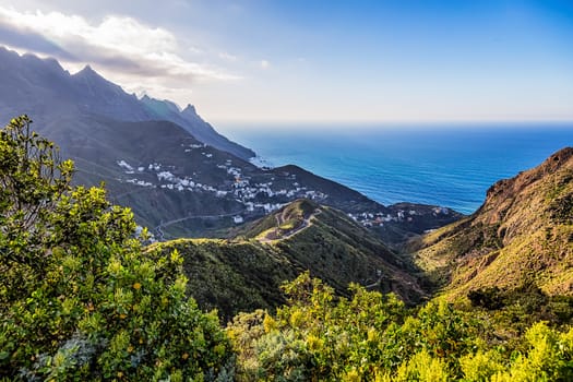 Small village in mountains with clouds landscape near the coast or shore of Atlantic ocean in Tenerife Canary island, Spain