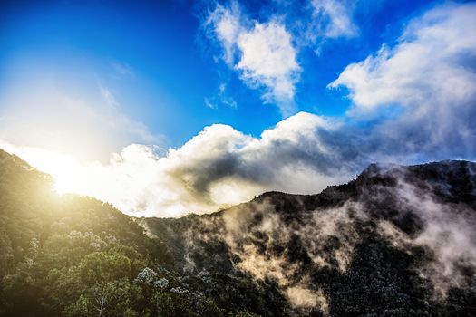 Green mountains or rocks with clouds and sun with sunlight on sky landscape in Tenerife Canary island, Spain