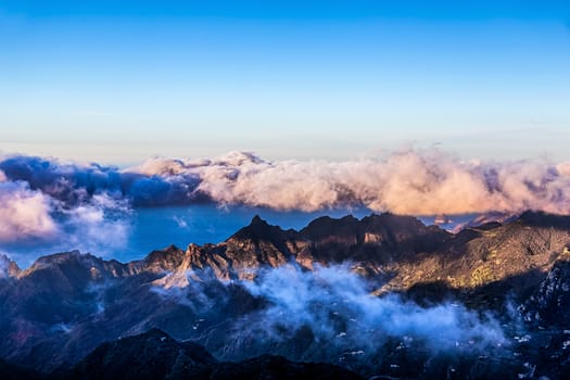 Mountains with white and pink clouds on blue sky landscape in Tenerife island, Spain at sunset