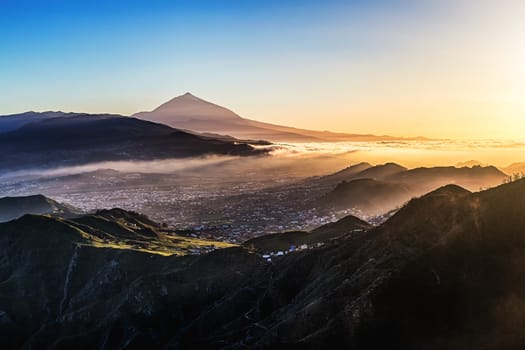 Sunset at evening in mountains and blue sky with fog and Teide volcano on background in Tenerife Canary island, Spain at spring or summer