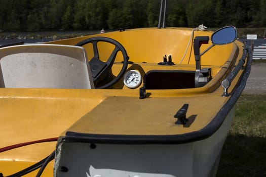 A boat on a trailer wating to get in the water, some details visible