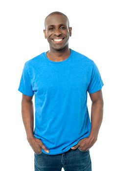 Smiling man posing with hands in pockets
