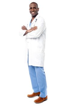 Side pose of smiling male doctor posing over white