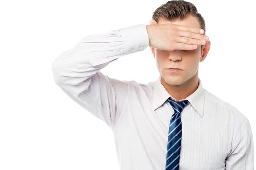 Male executive covering eyes with his hand