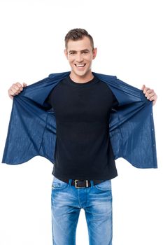 Smiling young man pulling his shirt in style