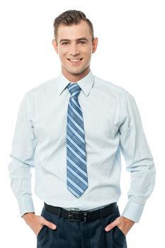 Young corporate man with hands in pockets