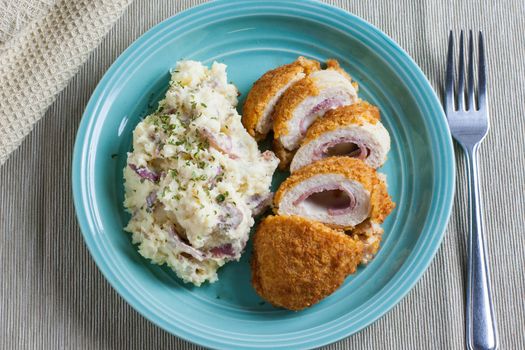 Chicken Cordon bleu on a plate with rustic mashed potatoes.
