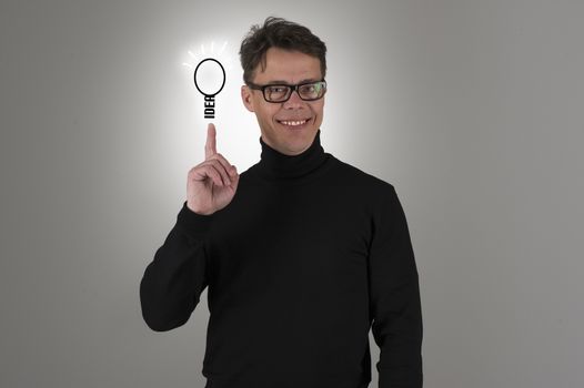 Conceptual image of a handsome happy proud man displaying his brainwave, clever business idea or innovation with a sketch of a shining light bulb balanced on his fingertip