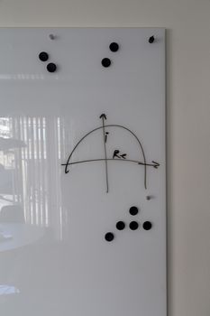 A white board with some magnets and drawings