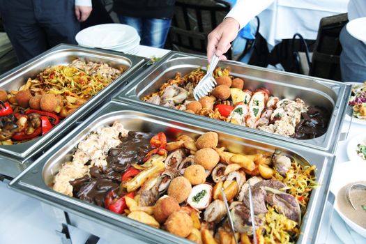 cook and fried meat in lunch counter at public catering restaurant