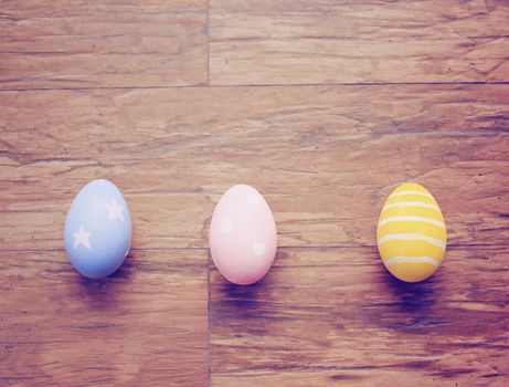 Top view of colorful easter eggs on wooden background with retro filter effect